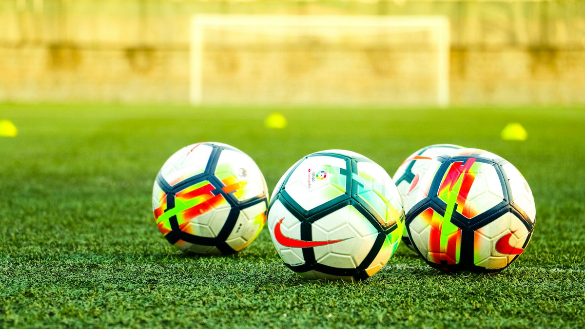 芝生の上に並んだサッカーボール