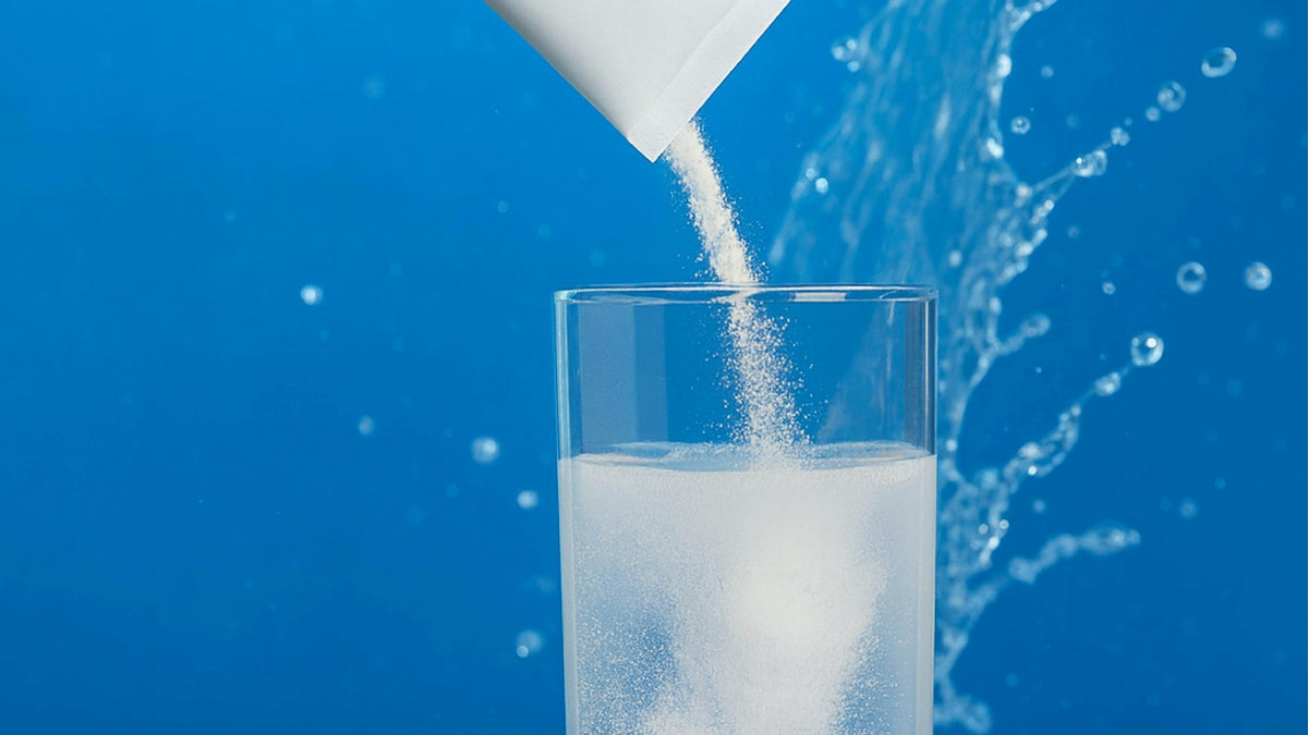 水の入ったグラスに粉末を注ぐ手