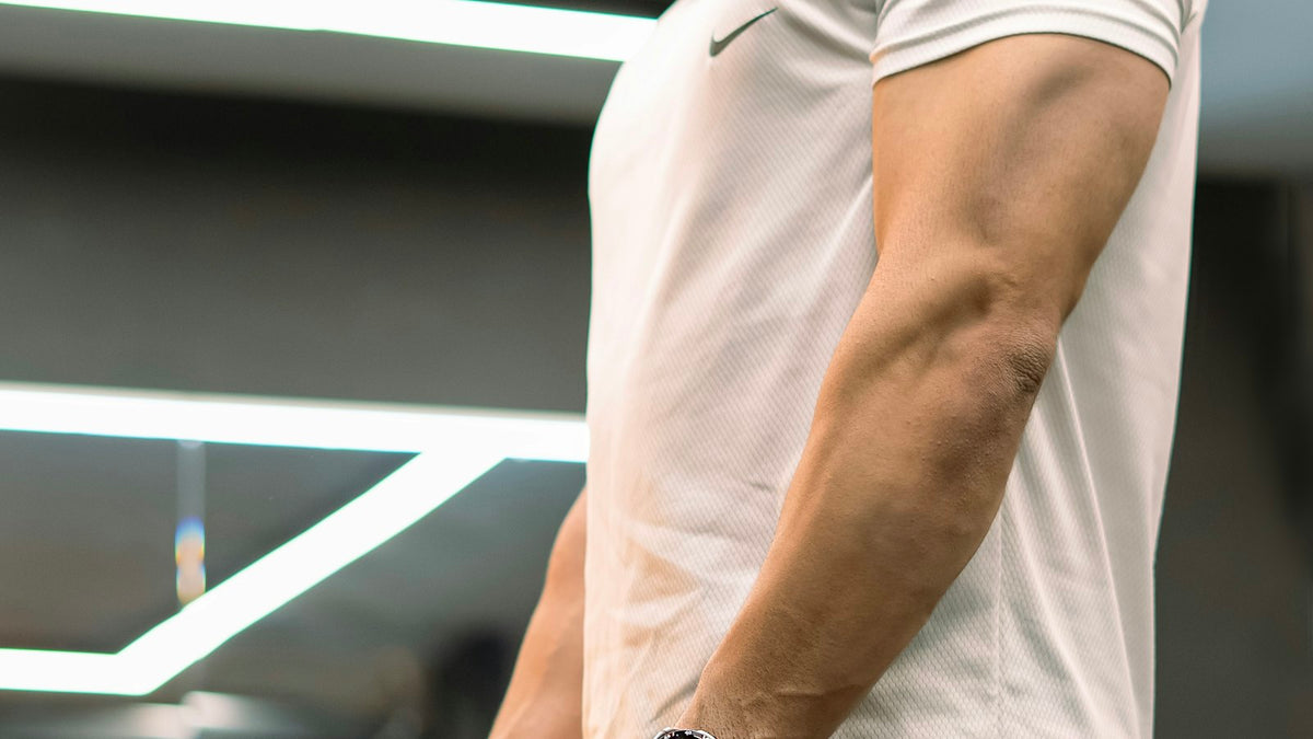 ジムのケーブルマシンでトレーニングする男性