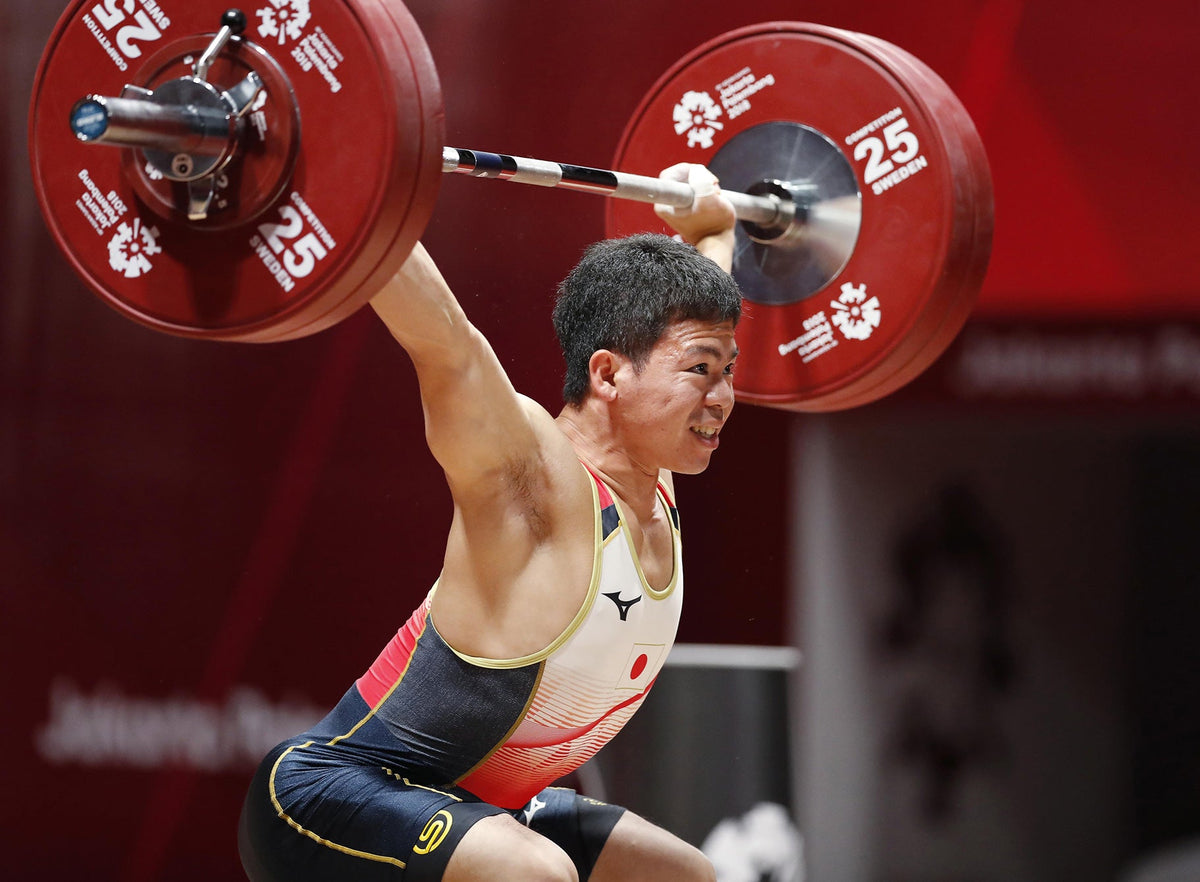 国際大会でバーベルを頭上に挙げる日本代表のウエイトリフティング選手